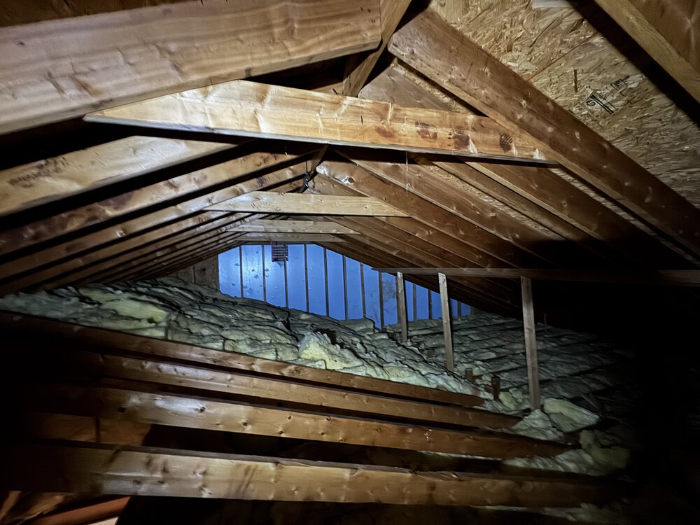 before of unused attic full of insulation and cross beams making space unable to be used