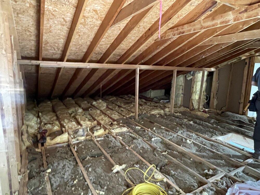 attic space cleared, and room rebuild started with newly laid insulation on attic floor between floor joists