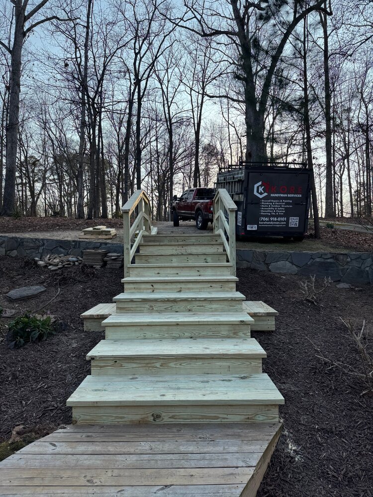 view from the upper parking lot to the new dual-railed 10-tread staircase and down to the lake home