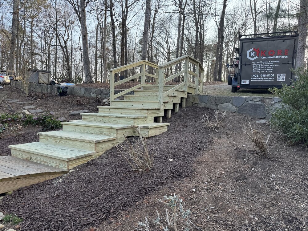 view looking up the completed dual-railed 10-tread stairway to the upper parking area with the Kore Handyman shop trailer in view
