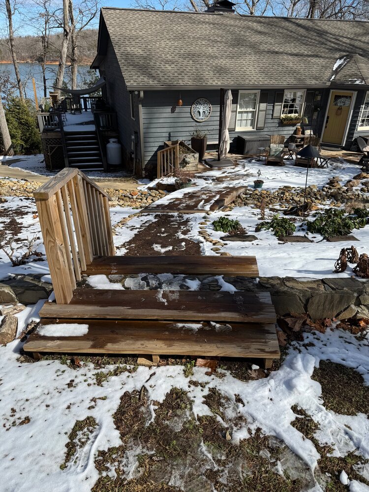 the old wood stairs lead sharply down to the wood bridge going towards the house