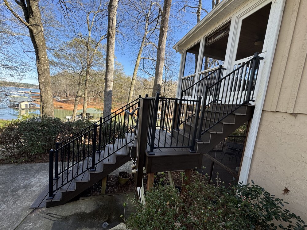 large newly built top deck has new sleek black metal railing all around the deck, and 4 white Adiorndack chairs sit on deck to enjoy the lake views