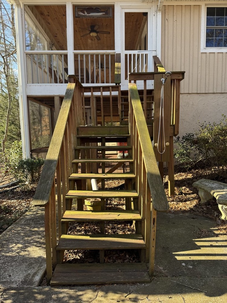 before side view of very worn, moss-covered wood stairs and railings with leading up to enclosed porch