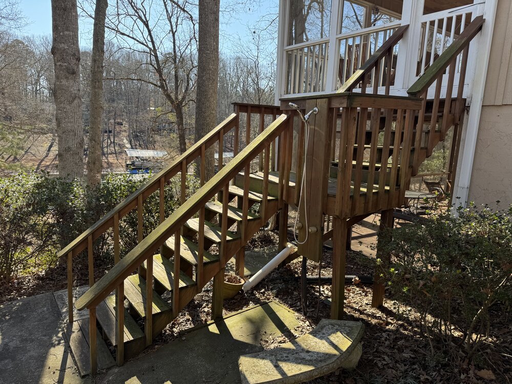 before view of wood stairs and railings, very worn and green with moss, leading up to enclosed porch