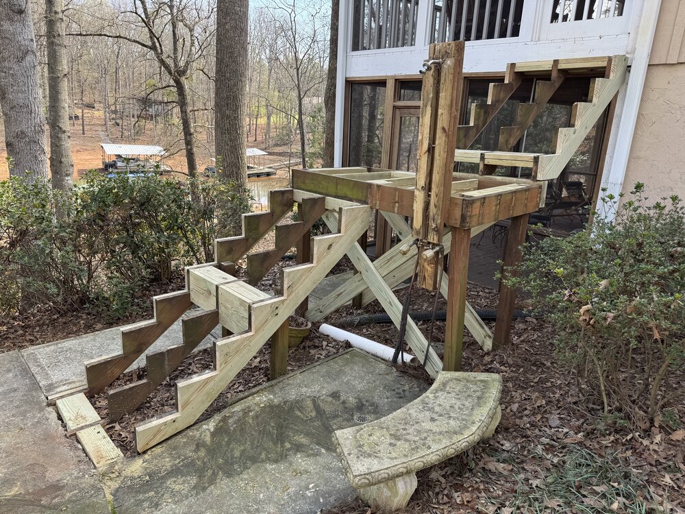 demo accomplished on wood stairs leading to enclosed porch, side view displaying new stringers put in place