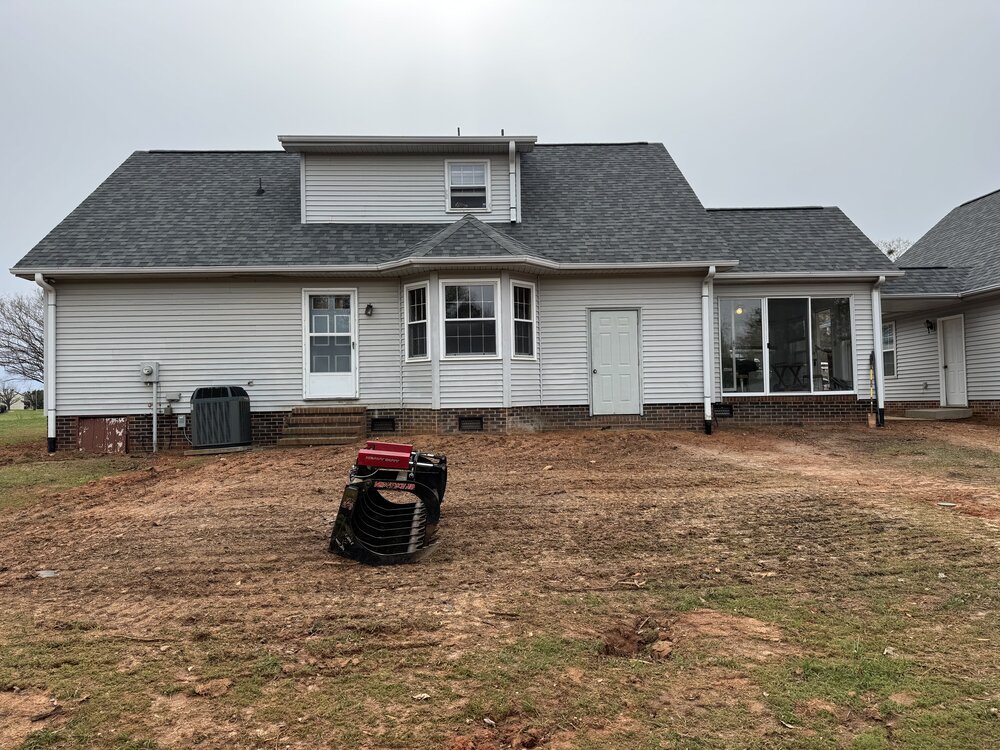 Before image of house with dirt backyard and ground prepped for construction.