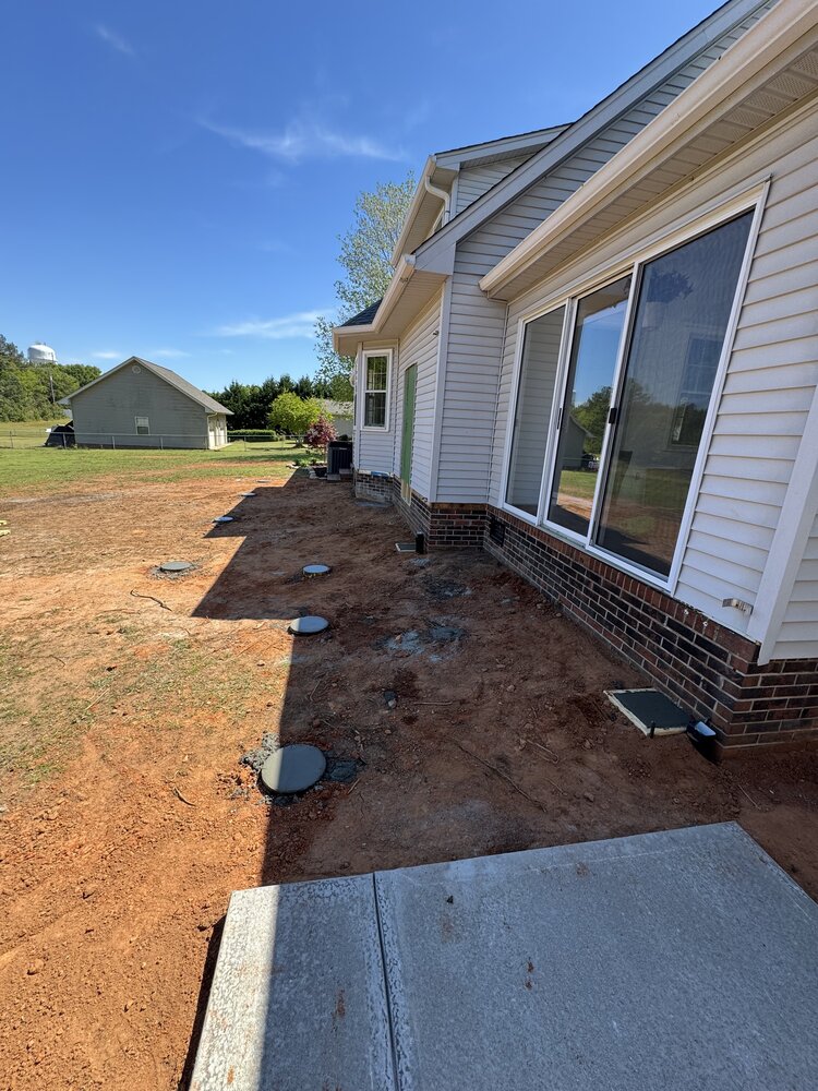 Round cement bases in ground to hold the deck foundation posts.