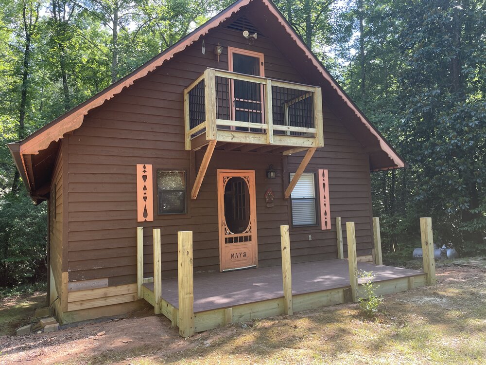 Progress view of balcony deck completely finished Trex Decking and new aluminum pickets framed in wood.
